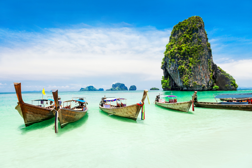 Longtale,Boats,At,The,Phuket,Beach,With,Limestone,Rock,On